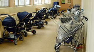 FILE PHOTO: Pushchairs are parked at the entrance of a day-nursery in Vincennes, near Paris, April 30, 2003. 