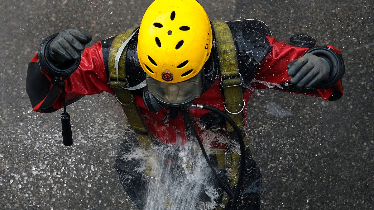 A rescue diver from the Fire Service department is rinsed after entering the sewage system to search anti-government protesters