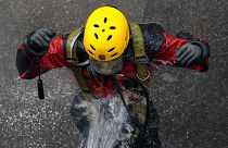 A rescue diver from the Fire Service department is rinsed after entering the sewage system to search anti-government protesters