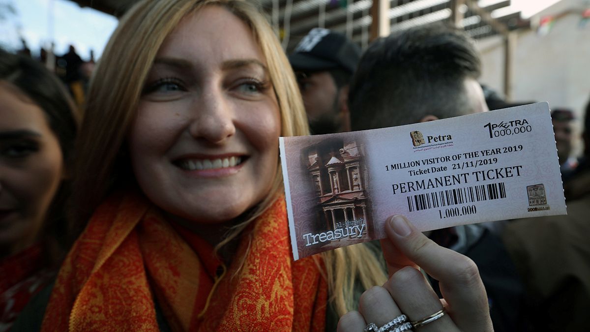 السائحة الأميركية أليسون كيري تحمل بطاقة رقم مليون لتتم رقم مليون سائح زاروا مدينة البتراء بالأردن في العام 2019. 21/11/2019