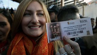 السائحة الأميركية أليسون كيري تحمل بطاقة رقم مليون لتتم رقم مليون سائح زاروا مدينة البتراء بالأردن في العام 2019. 21/11/2019