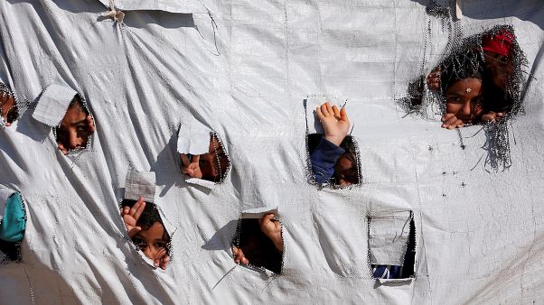 أطفال ينظرون من ثقوب في إحدى خيام مخيم الهول بمحافظة الحكسة السورية. 02/04/2019 أطفال ينظرون من ثقوب في إحدى خيام مخيم الهول بمحافظة الحكسة السورية. 02/04/2019