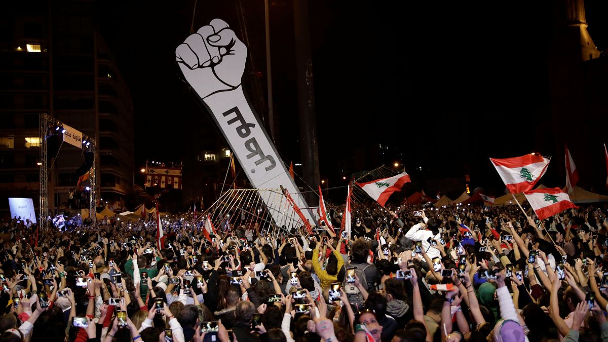 المحتجون يرفعون المجسم بعد إحراقه صباح الجمعة 