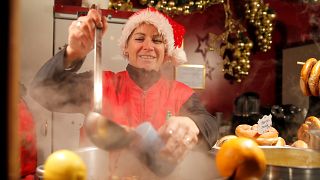 A street vendor pours mulled wine at the Christmas market in Strasbourg