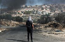 فلسطيني يقف أمام مستوطنة كدوميم بالقرب من الضفة الغربية- أرشيف رويترز