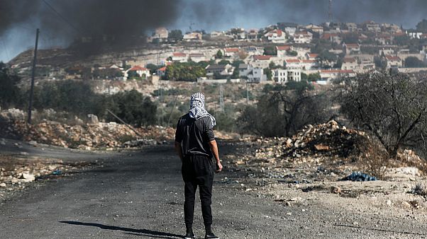 فلسطيني يقف أمام مستوطنة كدوميم بالقرب من الضفة الغربية- أرشيف رويترز فلسطيني يقف أمام مستوطنة كدوميم بالقرب من الضفة الغربية- أرشيف رويترز