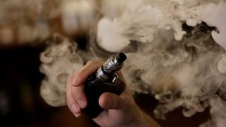 A man holds an electronic cigarette as he vapes at a Vape Shop in Monterrey, Mexico