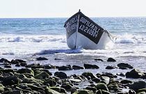 Sunseekers spring into action as migrants arrive at Spanish beach