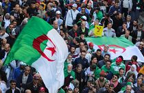صورة لمتظاهرين يحملون أعلام ولافتات تعبر عن رفضهم للانتخابات الرئاسية في العاصمة الجزائرية