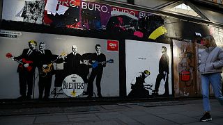 مشاة في لندن بجانب غرافيتي جرافيتي  بوريس جونسون ونائب حزب المحافظين والرئيس الأمريكي دونالد ترامب- أرشيف رويترز