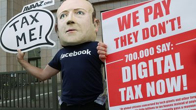 FILE PHOTO An activist wearing a mask depicting Facebook's CEO Mark Zuckerberg demonstrates during the European Union finance ministers meeting in Brussels, 2018