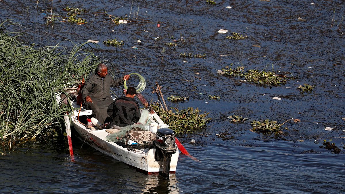 صيادون يتنقلون على متن قارب أثناء انخفاض المد على نهر النيل في حي شبرا الخيمة في القاهرة-02/12/219