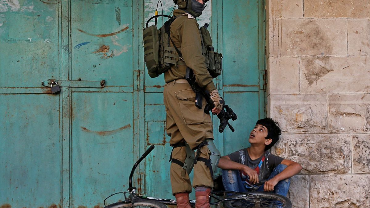 جندي إسرائيلي يحتجز طفلاً فلسطينياً خلال مظاهرة مناهضة لإسرائيل في الخليل بالضفة الغربية المحتلة من قبل إسرائيل- 29/11/2019