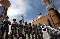 شرطة مكافحة الشغب الصينية أمام مسجد في إقليم شينجيانغ