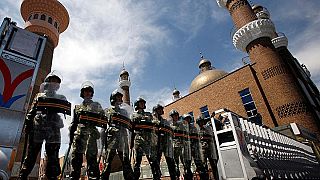 شرطة مكافحة الشغب الصينية أمام مسجد في إقليم شينجيانغ