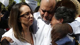 Julián LeBarón abraza a dos mujeres durante la protesta por el aniversario de la presidencia de López Obrador