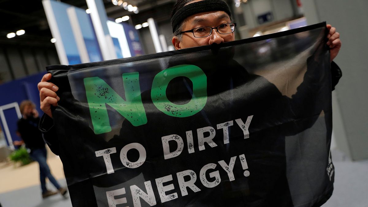 An activist protests as part of the Make Big Polluters Pay campaign inside the venue of the U.N. climate change conference (COP25) in Madrid, Spain, December 4, 2019