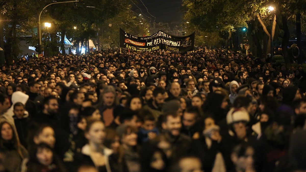 Διαδηλωτές κρατώντας πανό συμμετέχουν στην πορεία για τα 11 χρόνια από την δολοφονία του Αλέξανδρου Γρηγορόπουλου