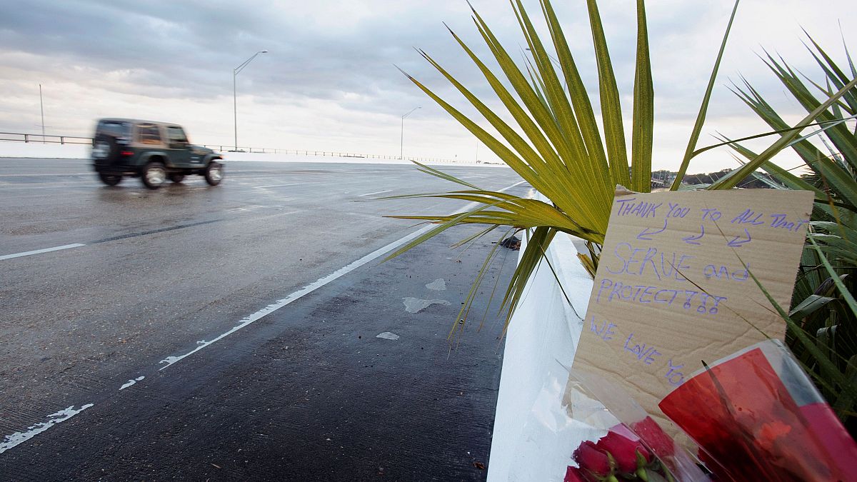 Flowers and a message are left on the entrance bridge after a member of the Saudi Air Force was the suspect in a shooting at Naval Air Station Pensacola
