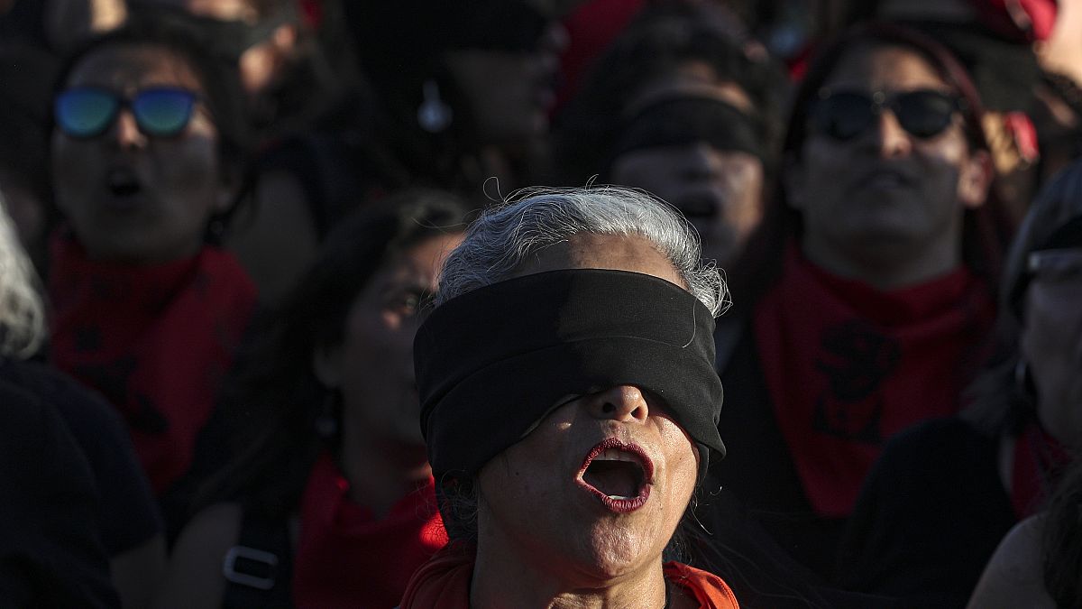 Women perform "A Rapist In Your Path," in a demonstration against gender-based violence in Santiago, Chile