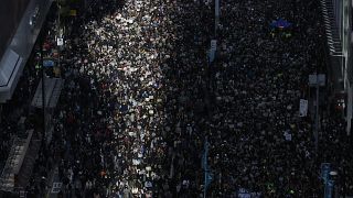 Pro-democracy protesters march on a street in Hong Kong, Sunday, Dec. 8, 2019. 