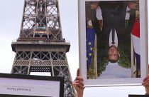 French climate activists hold stolen Macron portraits at protest