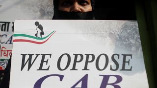 A woman holds a placard during a silent protest against the Citizenship Amendment Bill