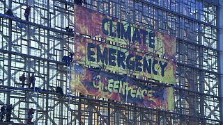 Greenpeace hang Climate Emergency banner at new EU headquarters