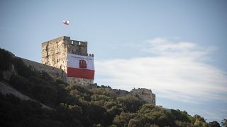 A Gibraltar flag reading "self determination is our right" is displayed on a castle and old jail during National Day celebrations in the British territory of Gibraltar in 2019