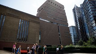 People walk past the Tate Modern gallery on August 5, 2019, the day after a six-year-old boy was thrown from a tenth-floor viewing platform. 