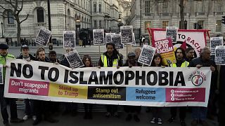People hold up a banner during a 'Unity Vigil' against racism and Islamophobia in reaction to Wednesday's attack, backdropped by the gates of Downing Street in London
