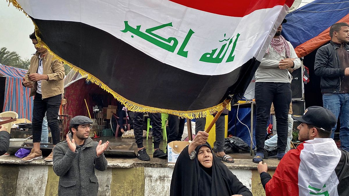 متظاهرة عراقية ترفع العلم في بغداد الأسبوع الفائت 