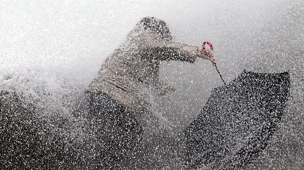 A woman tries to keep her balance as waves hit the seawall in Biarritz, southwestern France, Sunday, Dec.22, 2019 A woman tries to keep her balance as waves hit the seawall in Biarritz, southwestern France, Sunday, Dec.22, 2019