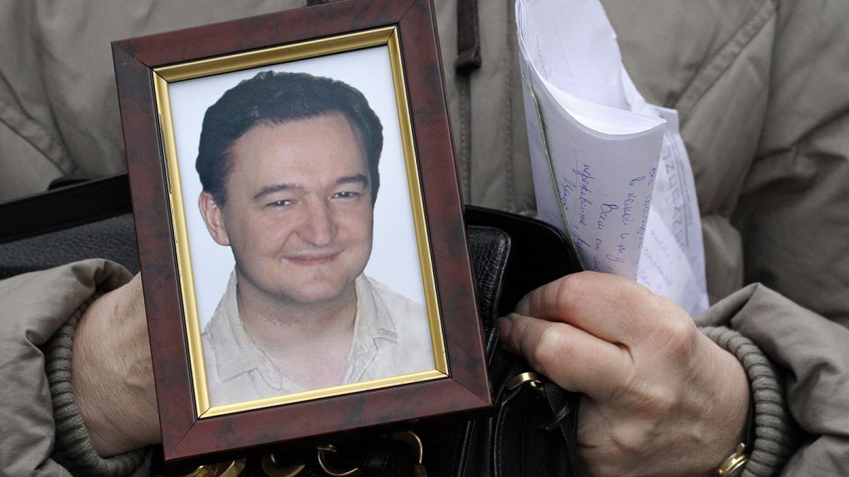 File photo a portrait of lawyer Sergei Magnitsky who died in jail, is held by his mother Nataliya Magnitskaya, on Monday, Nov. 30, 2009