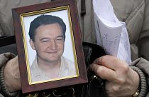 File photo a portrait of lawyer Sergei Magnitsky who died in jail, is held by his mother Nataliya Magnitskaya, on Monday, Nov. 30, 2009