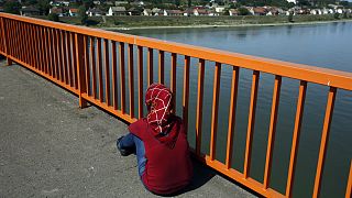 یک زن پناهجو روی پلی مسدود بر روی رودخانه دانوب