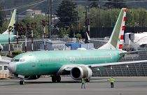 Workers stand near a Boeing 737 MAX built for American Airlines