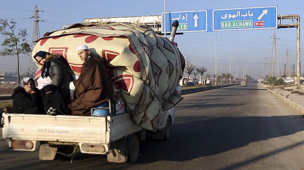 A family flees toward Turkey from Idlib as Syrian government forces shell the region A family flees toward Turkey from Idlib as Syrian government forces shell the region