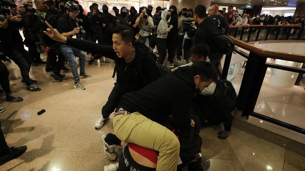 Plainclothes police officers arrest protesters in a Hong Kong mall.