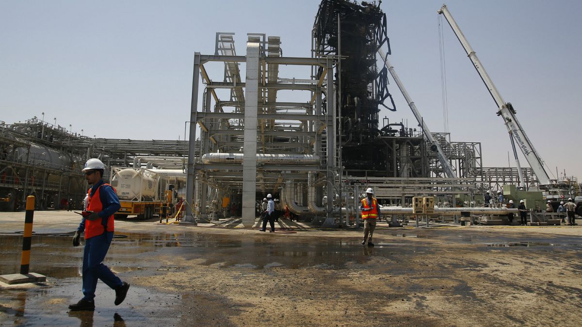 عامل يمشي أمام حقل خريص النفطي في خريص في السعودية