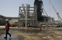 عامل يمشي أمام حقل خريص النفطي في خريص في السعودية