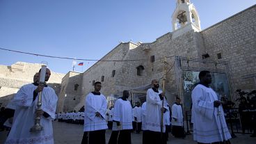 Clergymen attend Christmas celebrations outside the Church of the Nativity, on Christmas Eve, in the West Bank City of Bethlehem