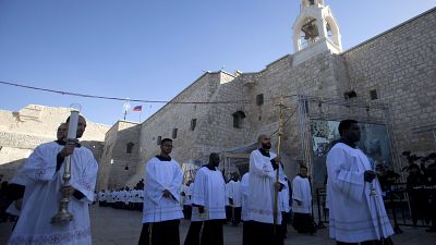 Clergymen attend Christmas celebrations outside the Church of the Nativity, on Christmas Eve, in the West Bank City of Bethlehem