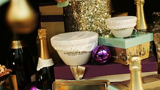 Bottles of wine and champagne, pies, decorations and Christmas puddings can be seen in the front window display of Fortnum & Mason, a central London's department store