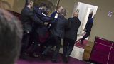 Police officers carry a pro-Serb opposition lawmaker in the parliament building in Podgorica, Montenegro, Friday, Dec. 27, 2019.