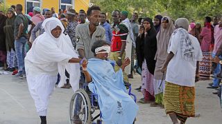  A civilian who was wounded in the Mogadishu suicide car bomb attack is helped