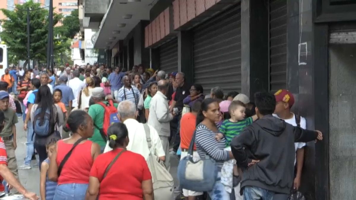 Venezolanos haciendo cola ante un comercio en Caracas