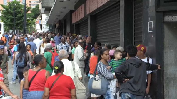 Venezolanos haciendo cola ante un comercio en Caracas Venezolanos haciendo cola ante un comercio en Caracas