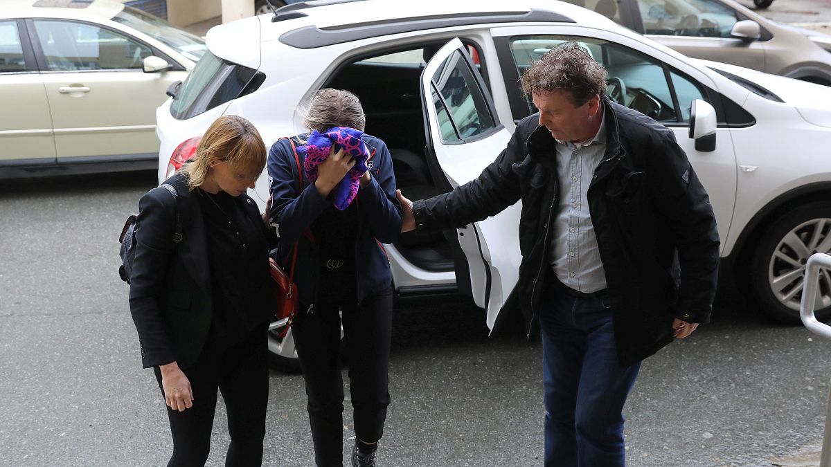 A British woman, accused of lying about being gang raped, covers her face as she arrives at the Famagusta courthouse in Paralimni.