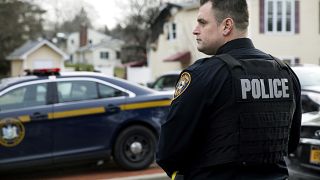 A Ramapo police officer directs traffic outside of a rabbi's residence in Monsey, N.Y.